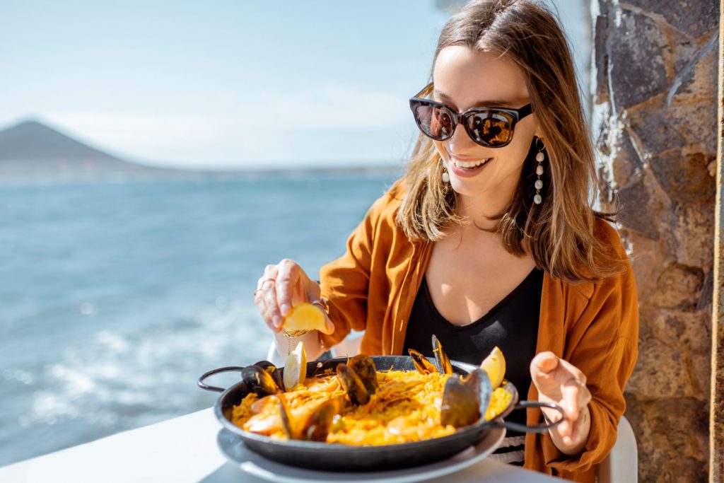 A girl tasting a good seafood paella